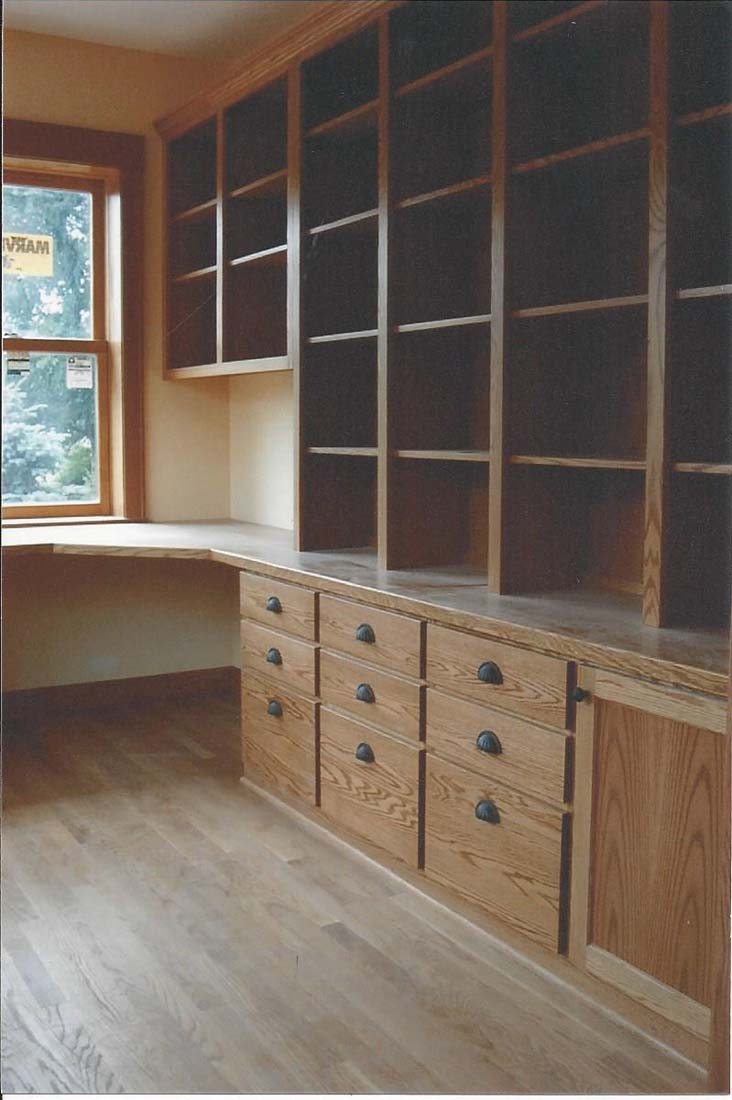 A room with lots of shelves and drawers and a window
