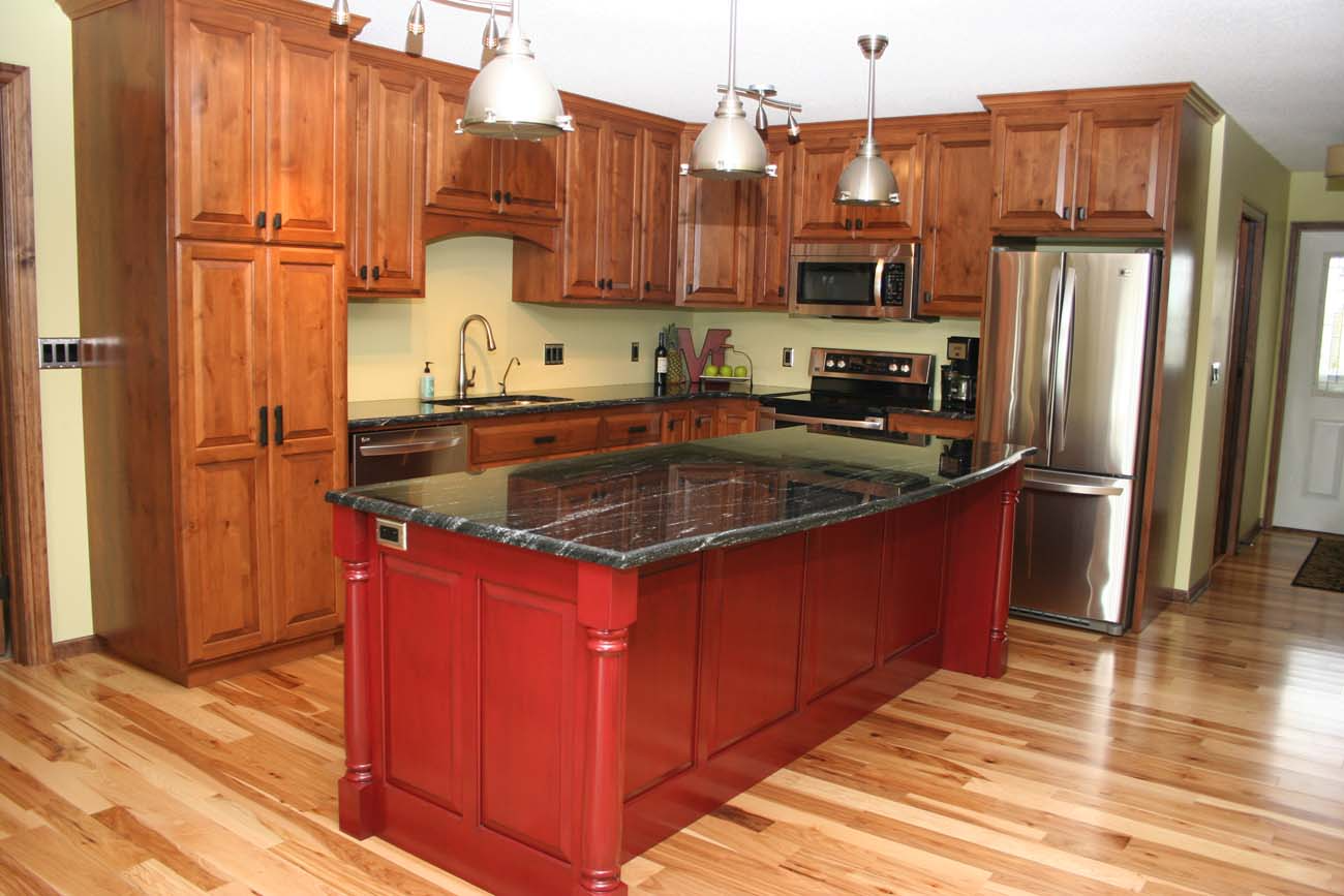 A kitchen with a large red island in the middle