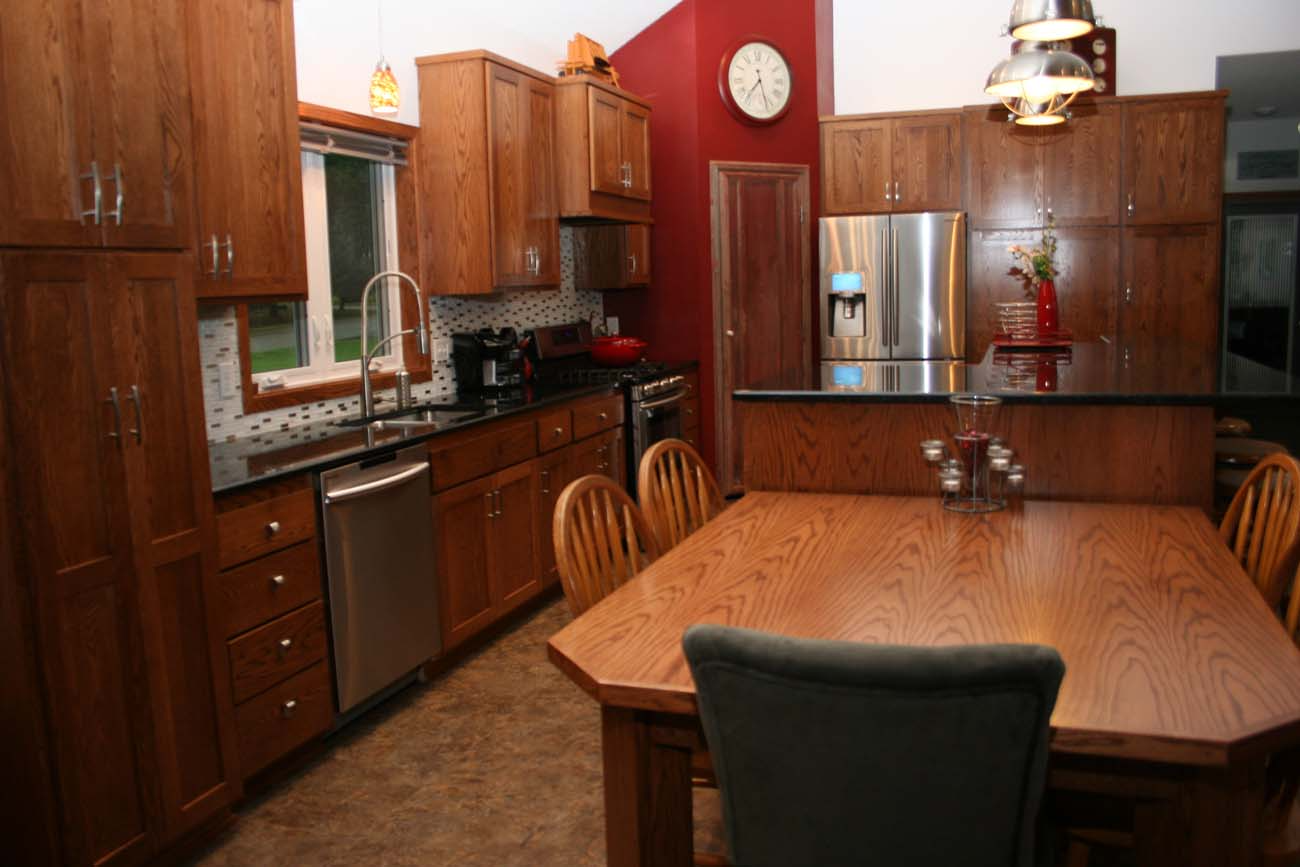 A kitchen with a table and chairs and a clock on the wall