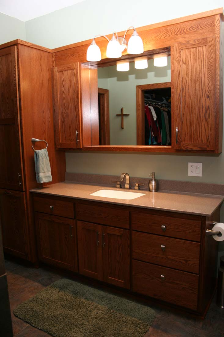 A bathroom with wooden cabinets and a large mirror