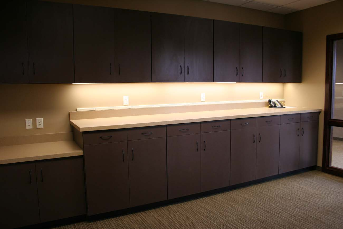 A kitchen with a lot of cabinets and a phone on the counter