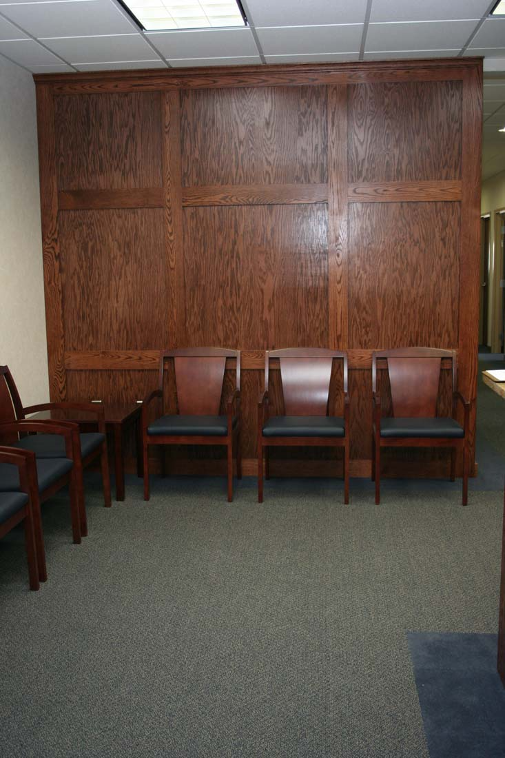 A row of chairs in a waiting room with a wooden wall