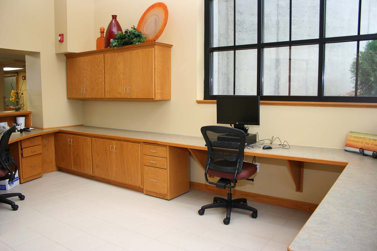 A desk with a computer and a chair in a room