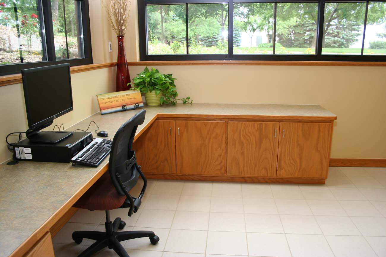 A desk with a computer on it and a chair