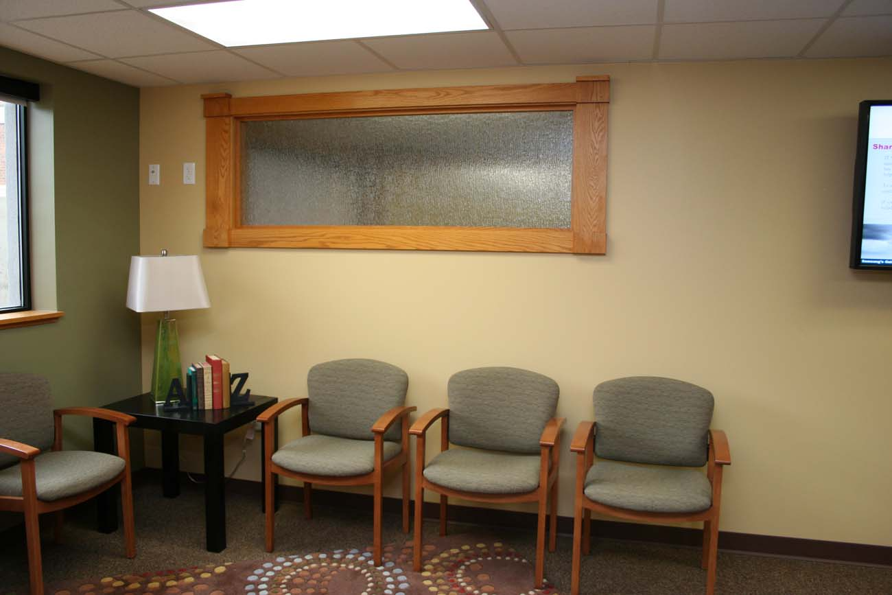 A waiting room with four chairs and a table