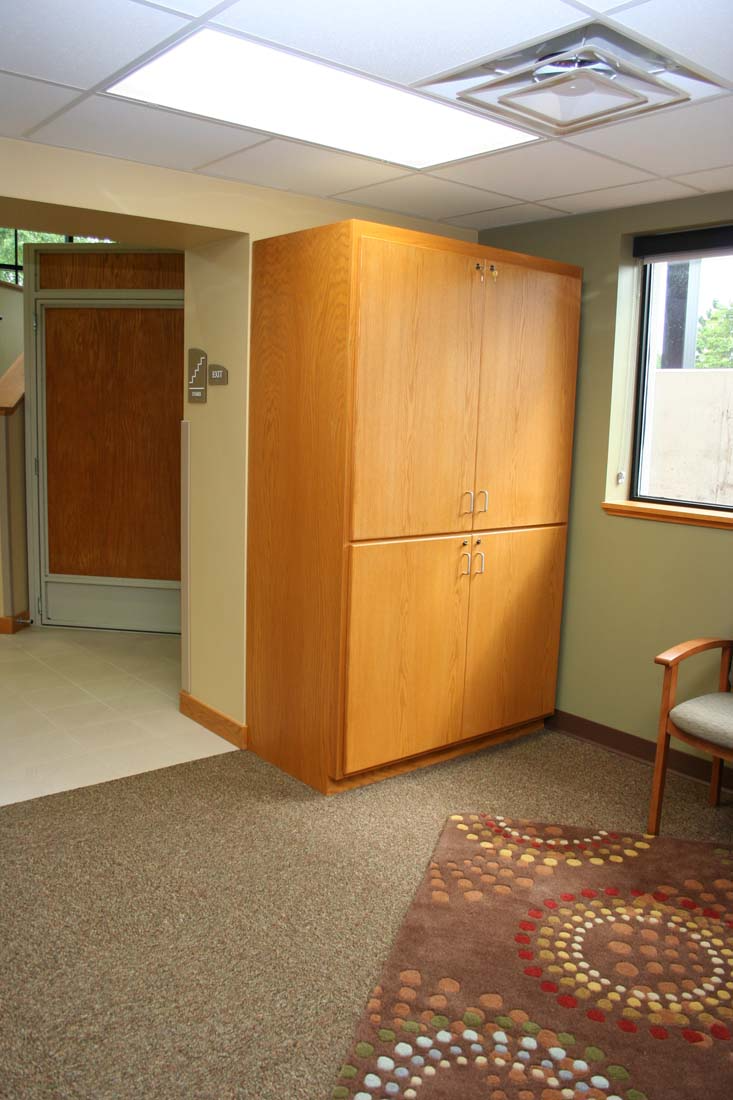 A room with a large cabinet and a chair in it