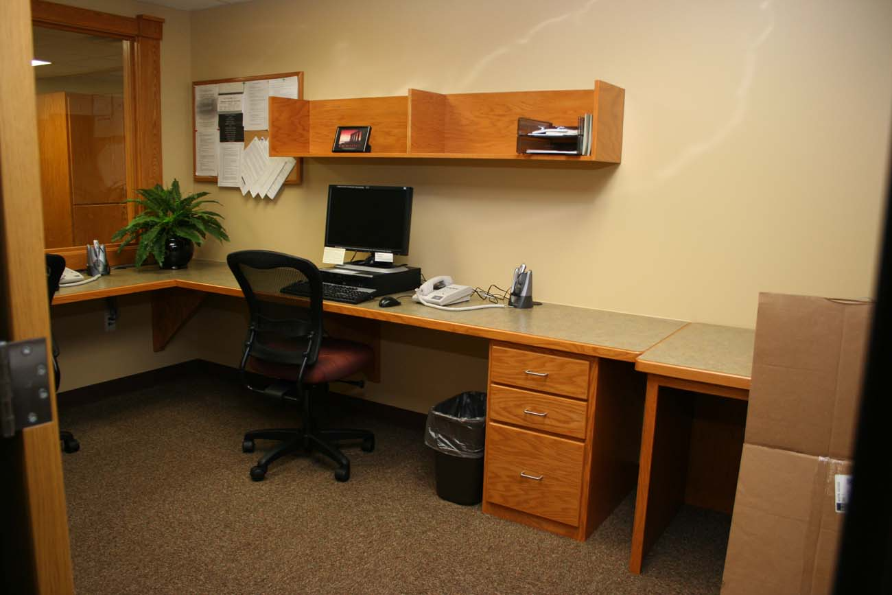 A room with a desk and chair and a computer on it