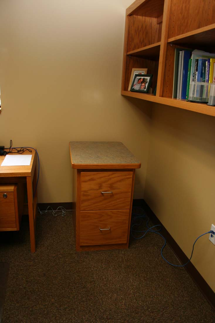 A small office with a desk and a drawer
