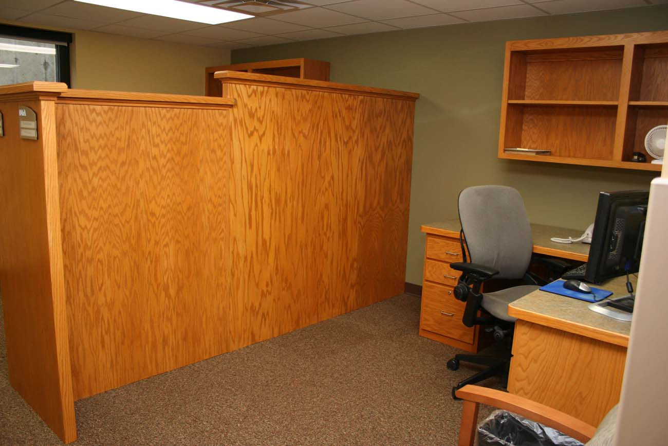 A cubicle in an office with a desk and chair