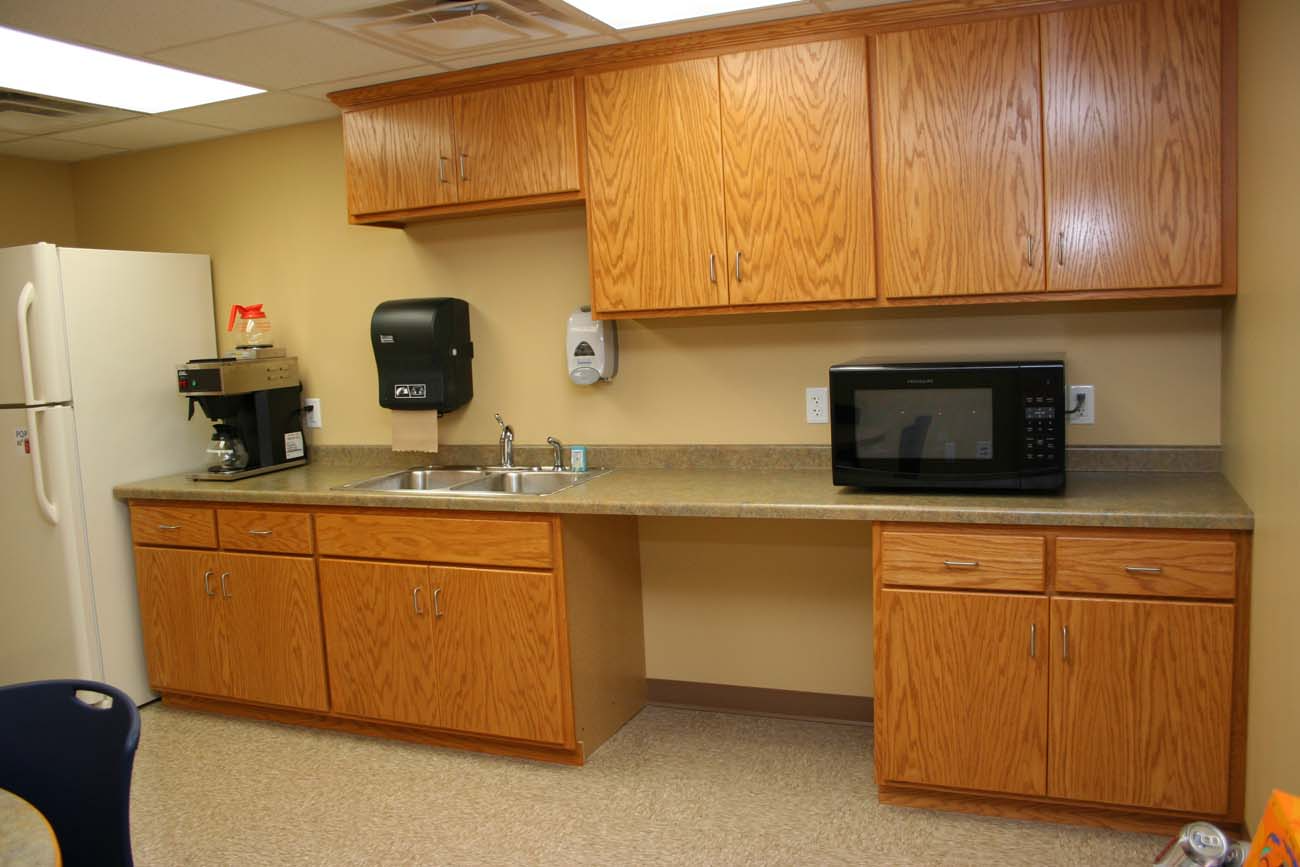 A kitchen with a sink , microwave and refrigerator