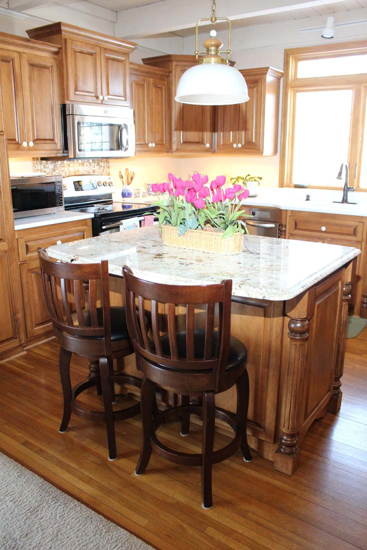 A kitchen with wooden cabinets and a large island