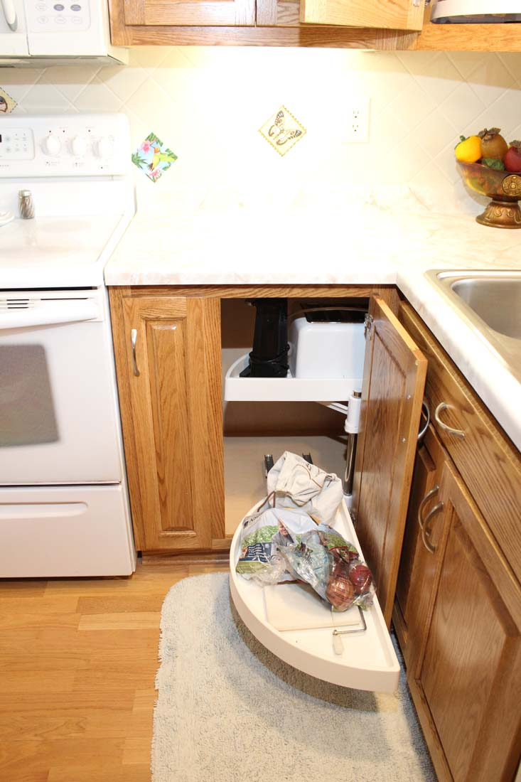 A kitchen with a stove , sink , and cabinets.