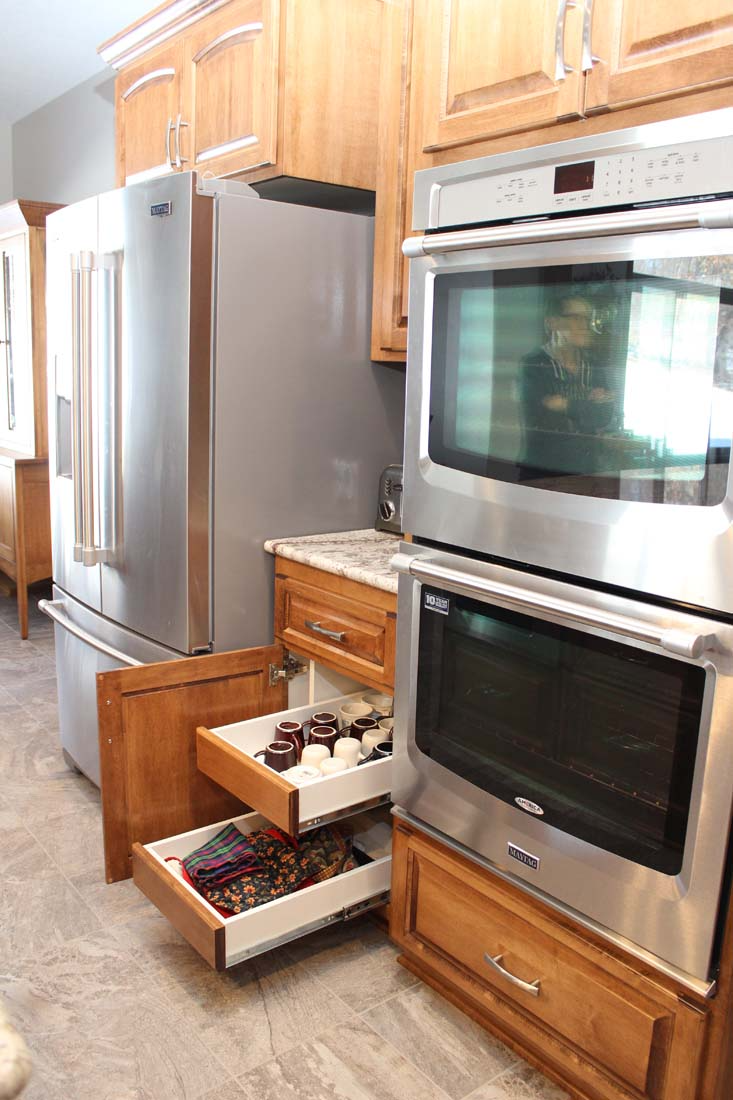 A kitchen with stainless steel appliances and wooden cabinets.