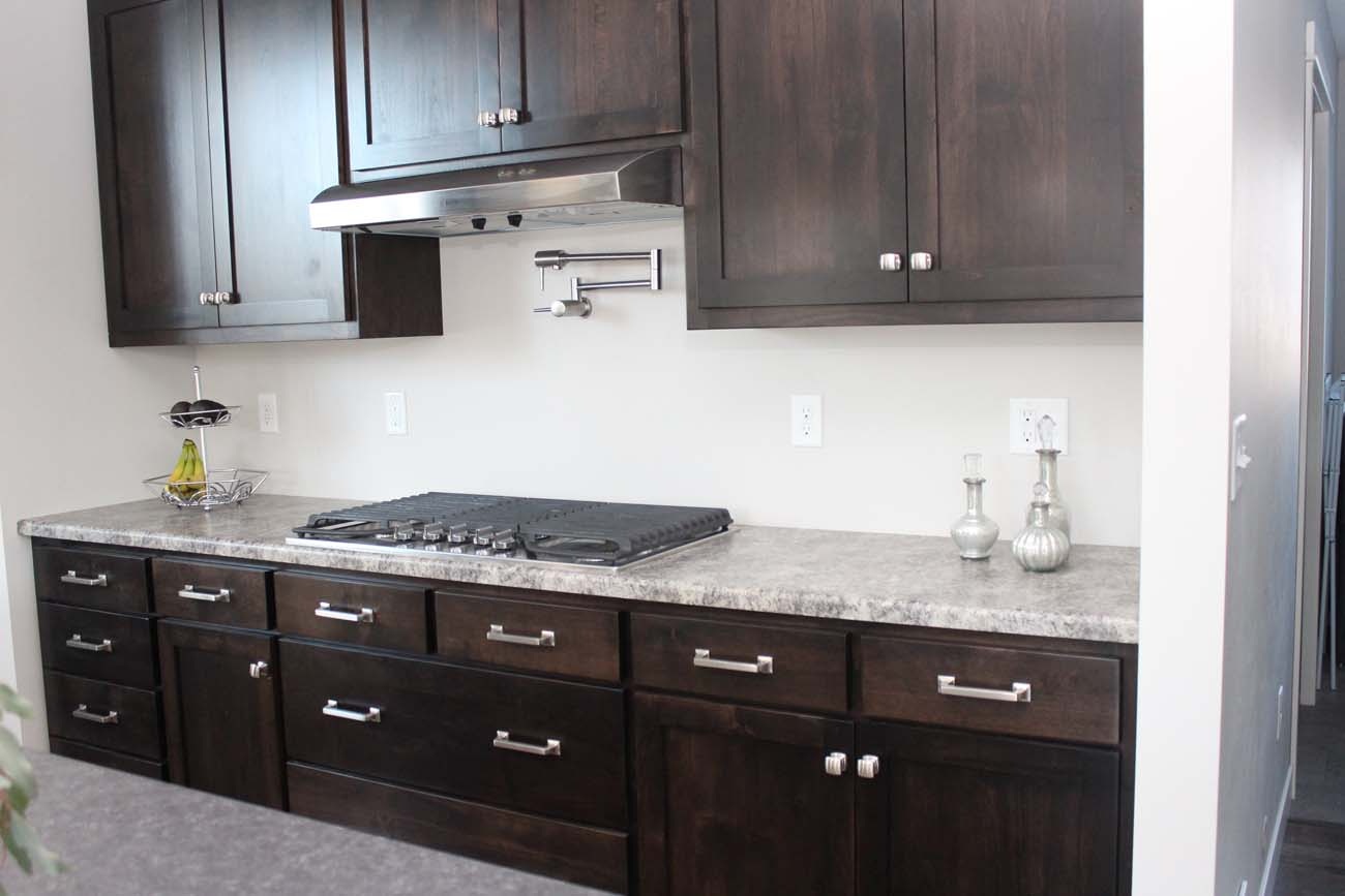 A kitchen with dark wood cabinets and granite counter tops
