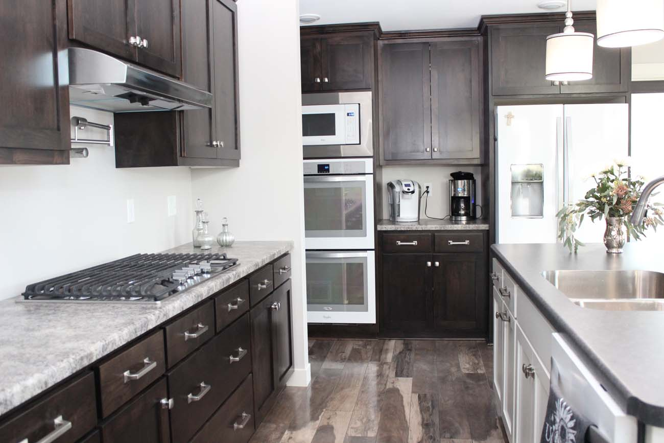 A kitchen with dark wood cabinets and stainless steel appliances