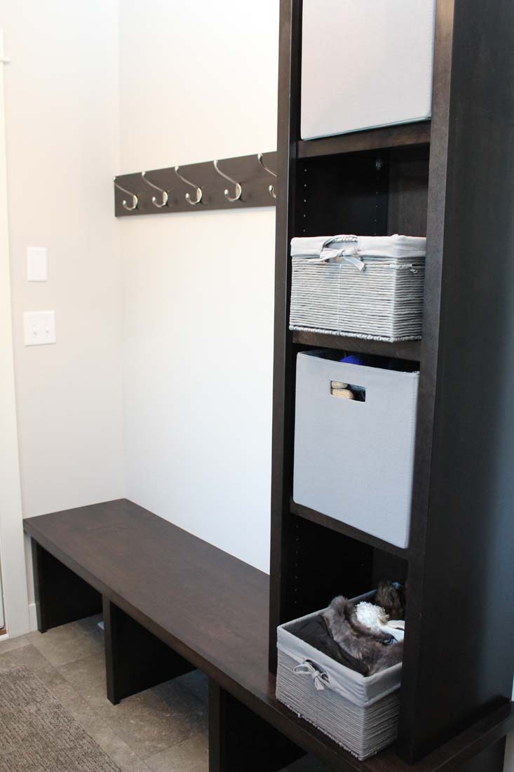 A hallway with a bench and a shelf with baskets on it