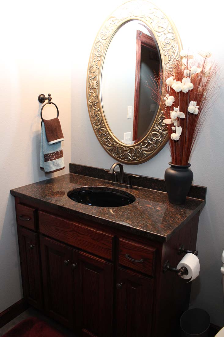 A bathroom with a sink a mirror and a vase of flowers