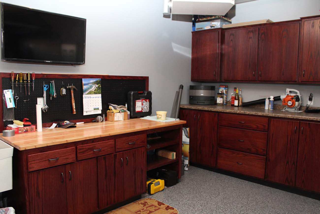 A kitchen with wooden cabinets and a flat screen tv