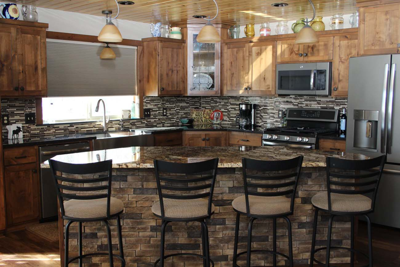 A kitchen with a granite counter top and stainless steel appliances