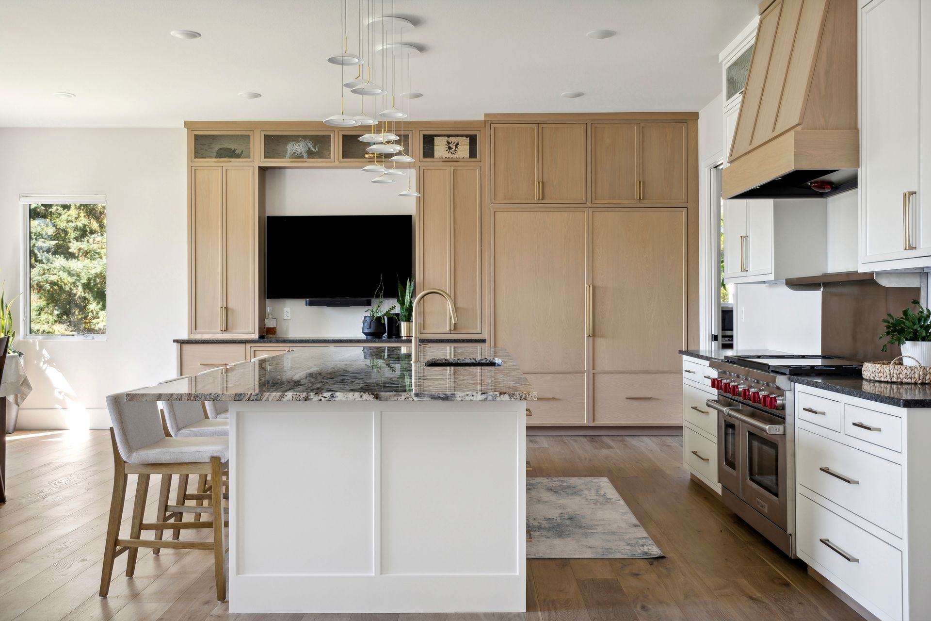 A kitchen with white cabinets , wooden cabinets , stainless steel appliances and a large island.