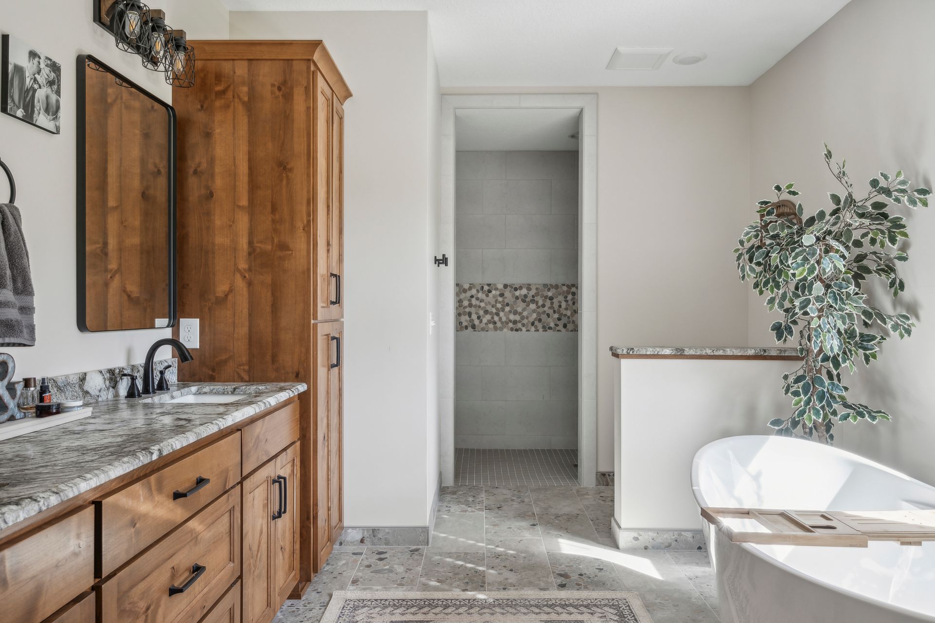 A bathroom with two sinks , a tub , a mirror and a walk in shower.