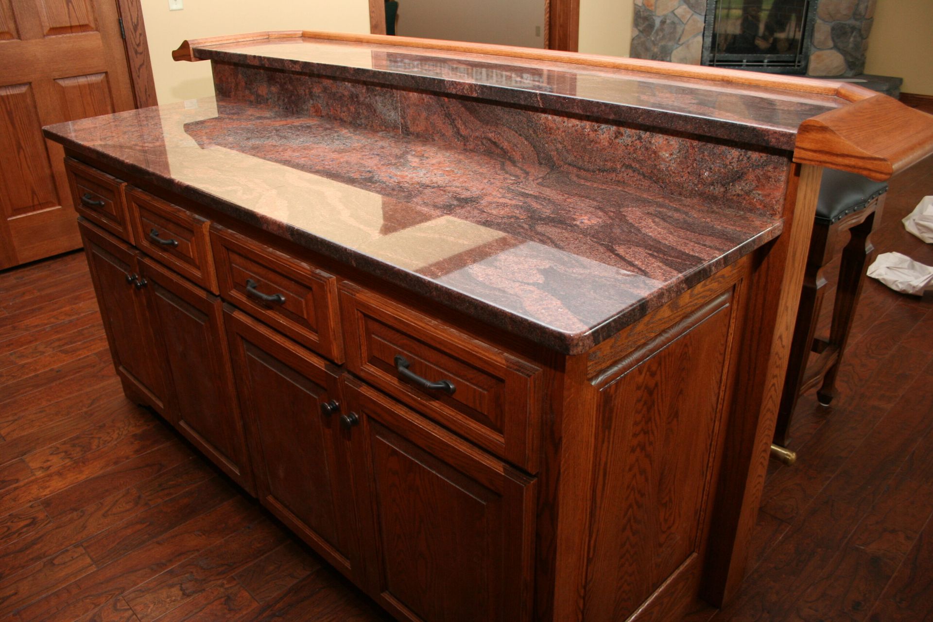 A kitchen counter with a granite counter top and wooden cabinets.