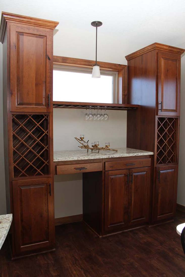 A kitchen with wooden cabinets and a wine rack