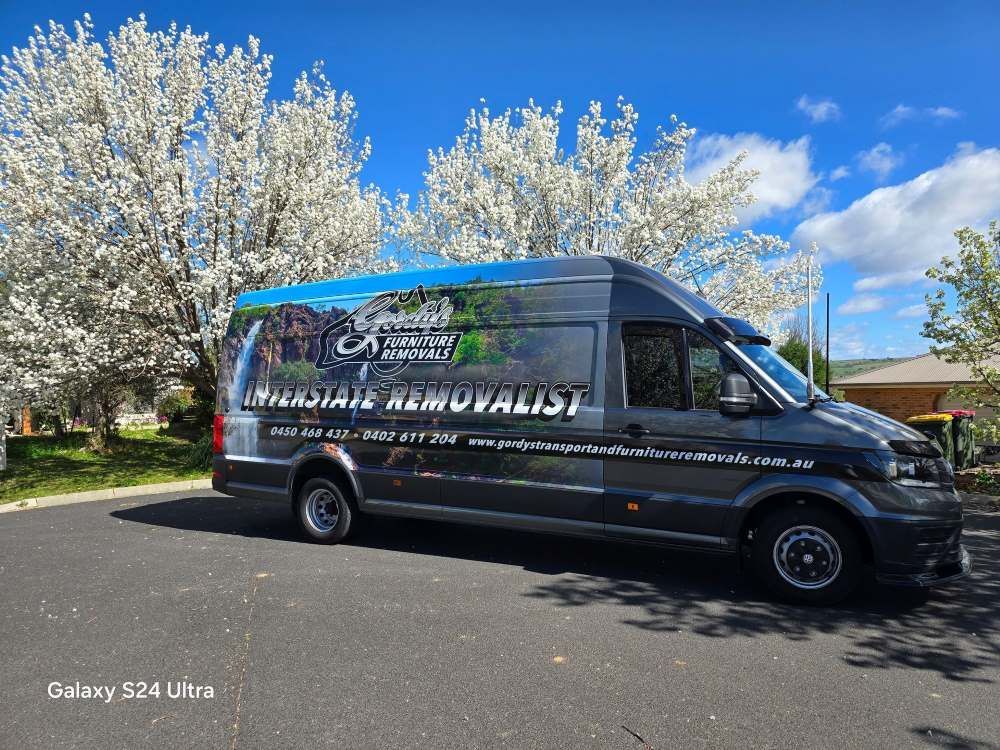 A Van is Parked on the Side of the Road in Front of a Tree — Gordy's Furniture Removals in Mudgee, NSW