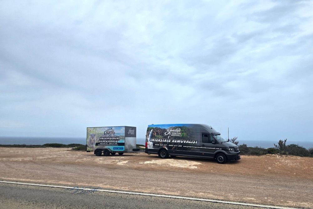 Two Moving Trucks Are Parked Next to Each Other — Gordy's Furniture Removals in Bathurst, NSW