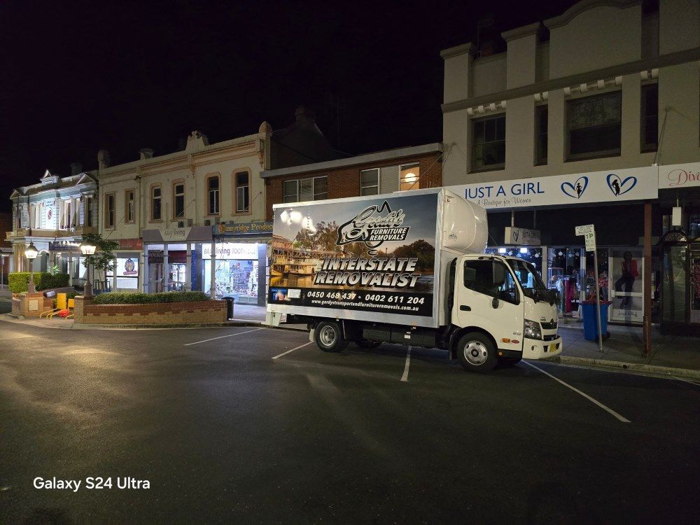 A Small Truck With Business Logo at Night— Gordy's Furniture Removals in Bathurst, NSW