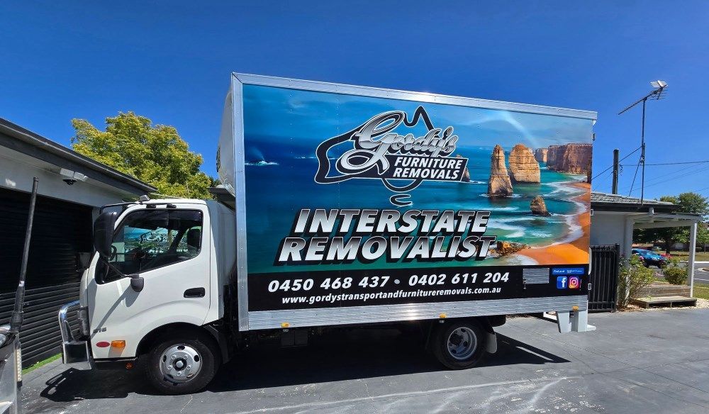 A White Interstate Removals Truck is Parked in a Parking Lot — Gordy's Furniture Removals in Katoomba, NSW