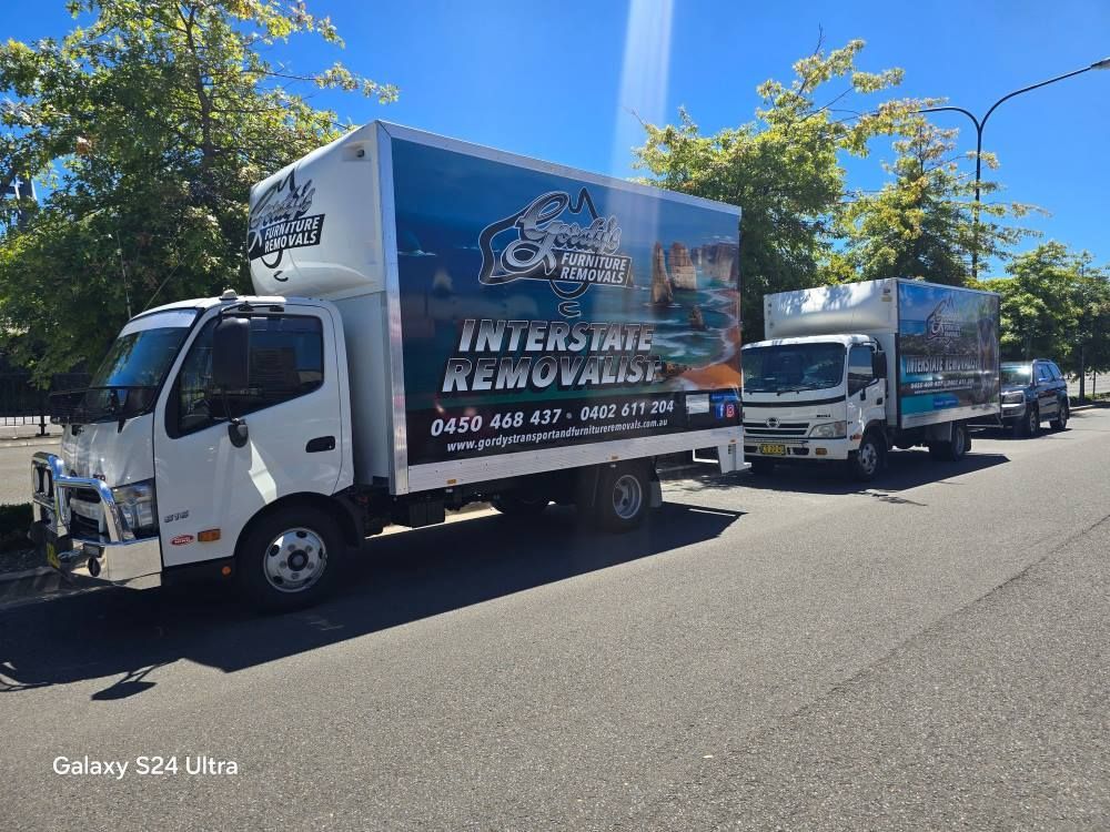 Three Moving Trucks Are Parked on the Side of the Road — Gordy's Furniture Removals in Bathurst, NSW