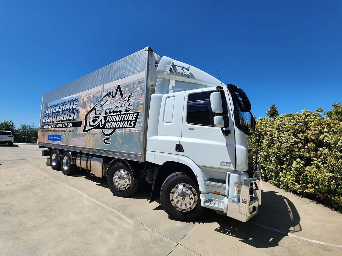 A Large White Truck is Parked in a Parking Lot — Gordy's Furniture Removals in Bathurst, NSW