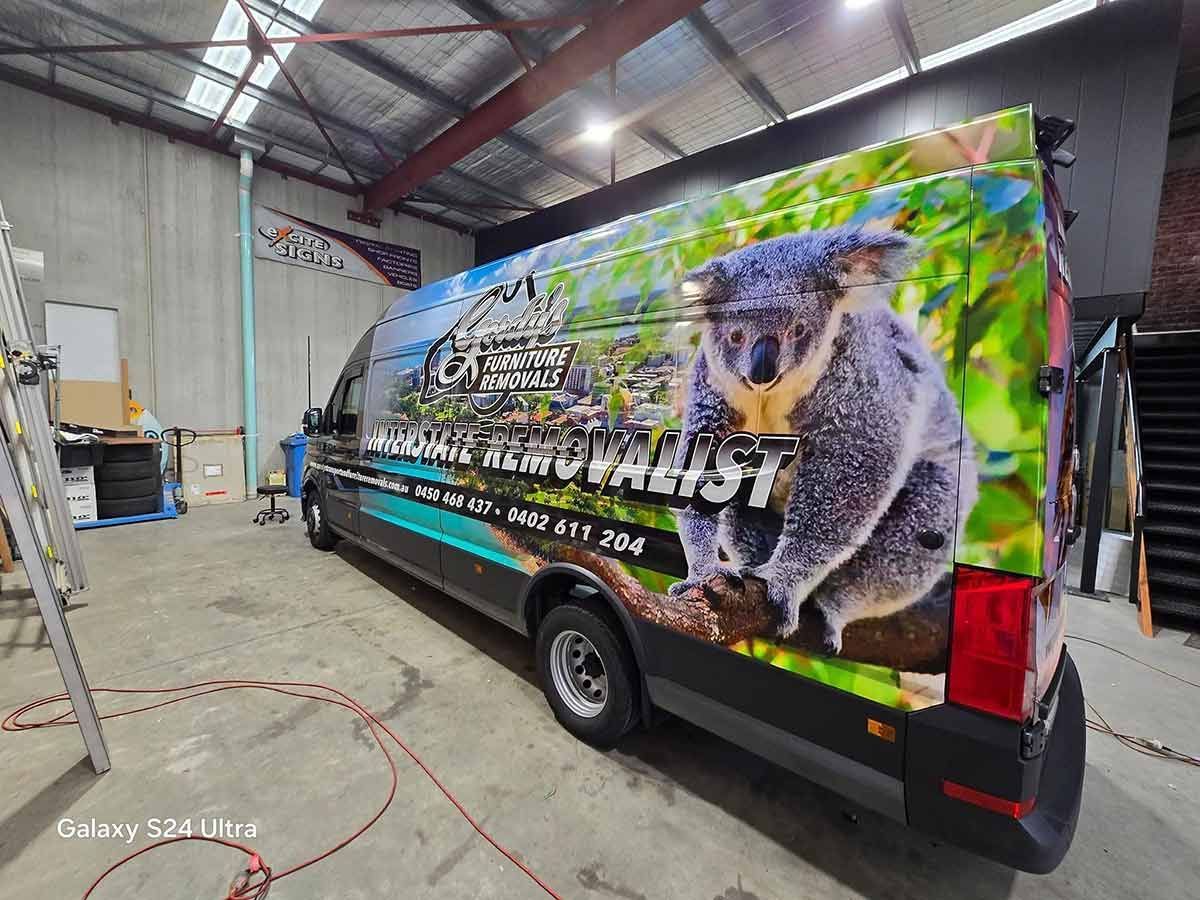 A Van With A Picture Of A Koala On The Side Is Parked In A Garage — Gordy's Furniture Removals in Bathurst, NSW