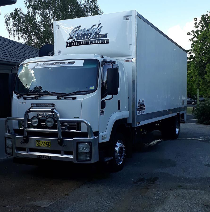 A White Truck Is Parked In Front Of A House — Gordy's Furniture Removals in Bathurst, NSW