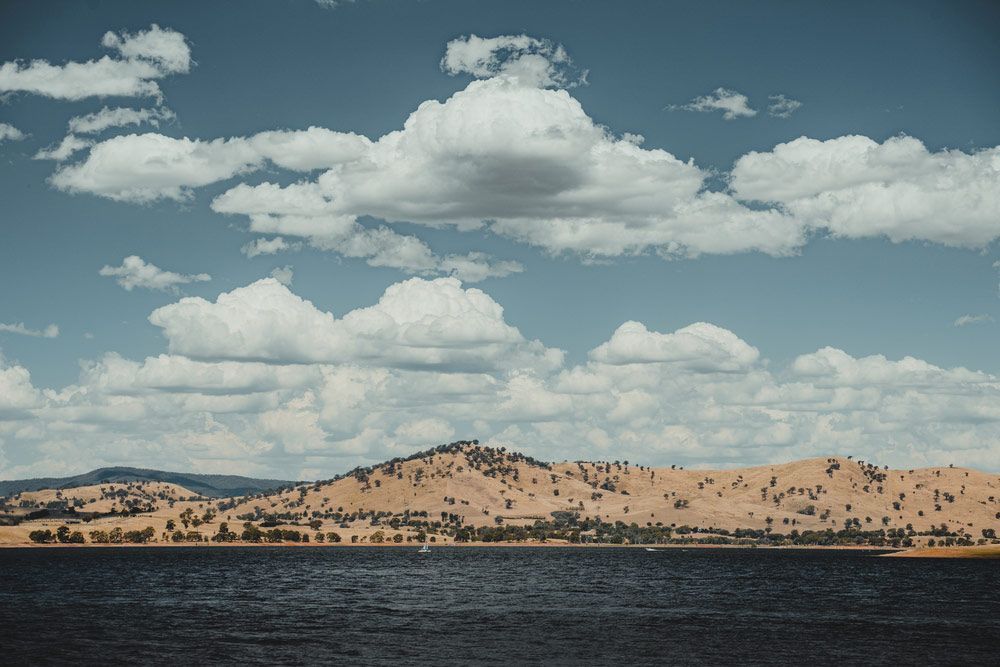 A Lake With Mountains In The Background And Clouds In The Sky — Gordy's Furniture Removals in Albury, NSW