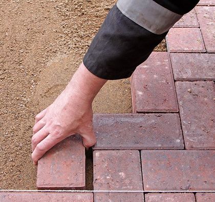 a person is laying bricks on the ground