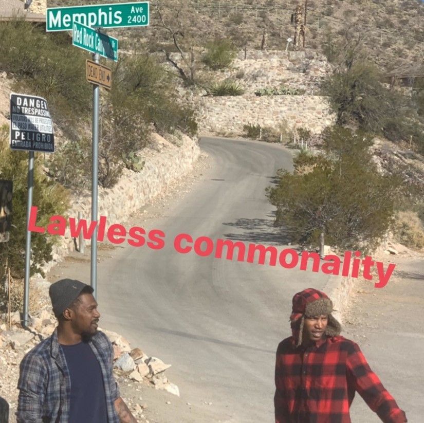 Two men standing on the side of a road with lawless commonality written in red