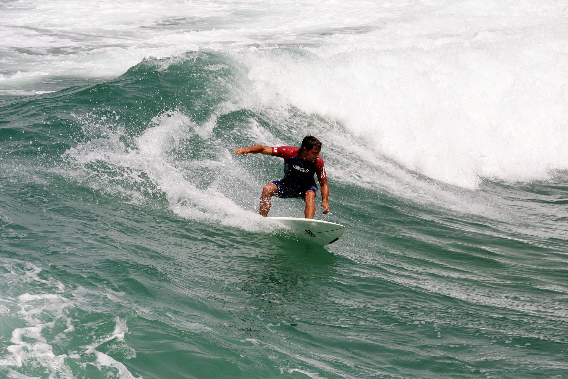 A man is riding a wave on a surfboard in the ocean