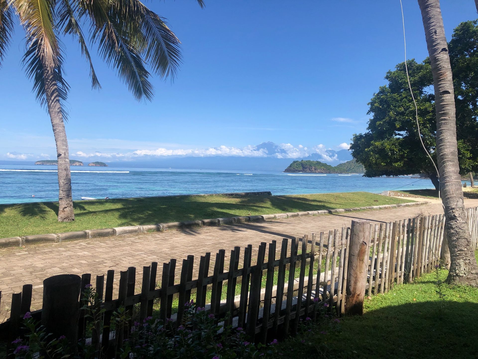 A wooden fence with a view of the ocean behind it