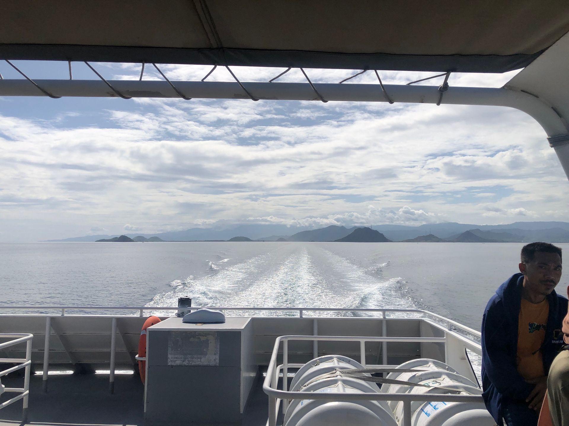 A man stands on the deck of a boat looking out over the ocean