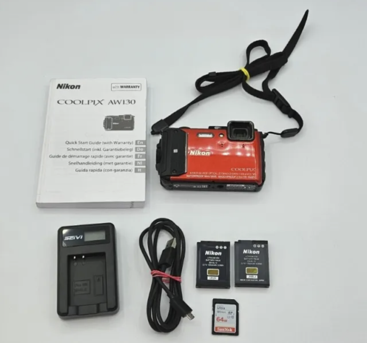 A nikon camera is surrounded by various accessories