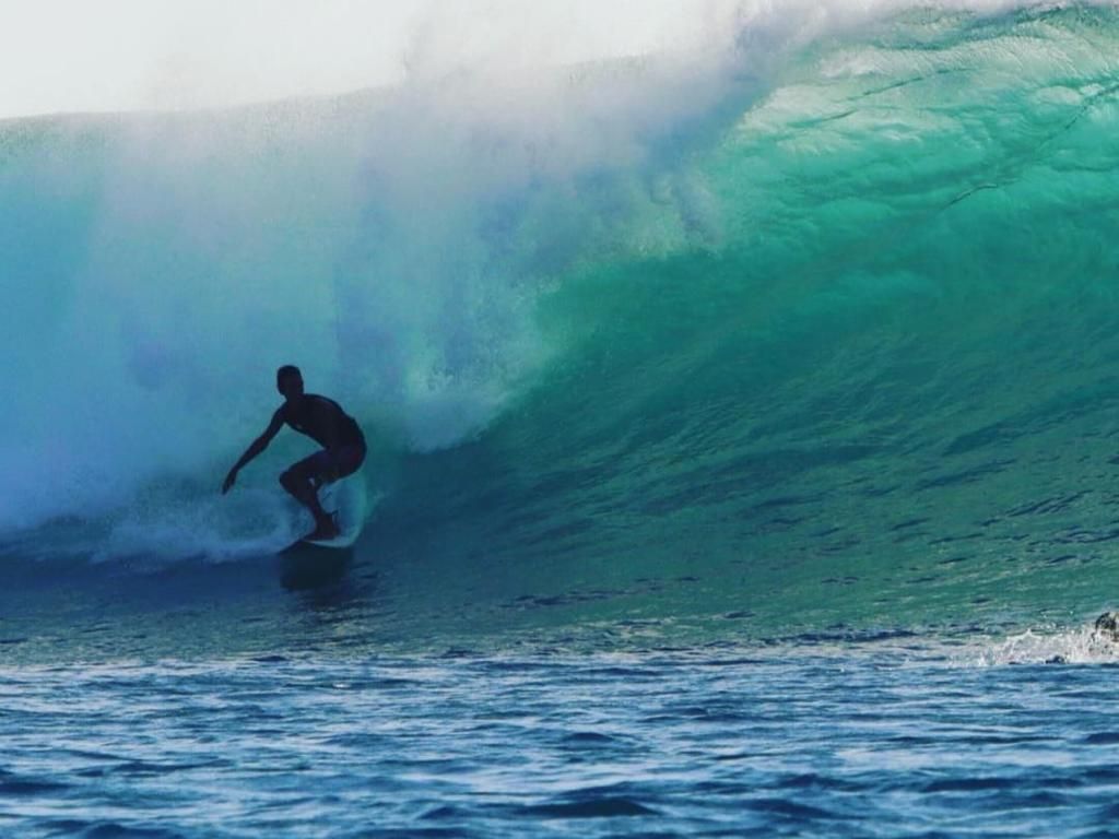A man is riding a wave on a surfboard in the ocean