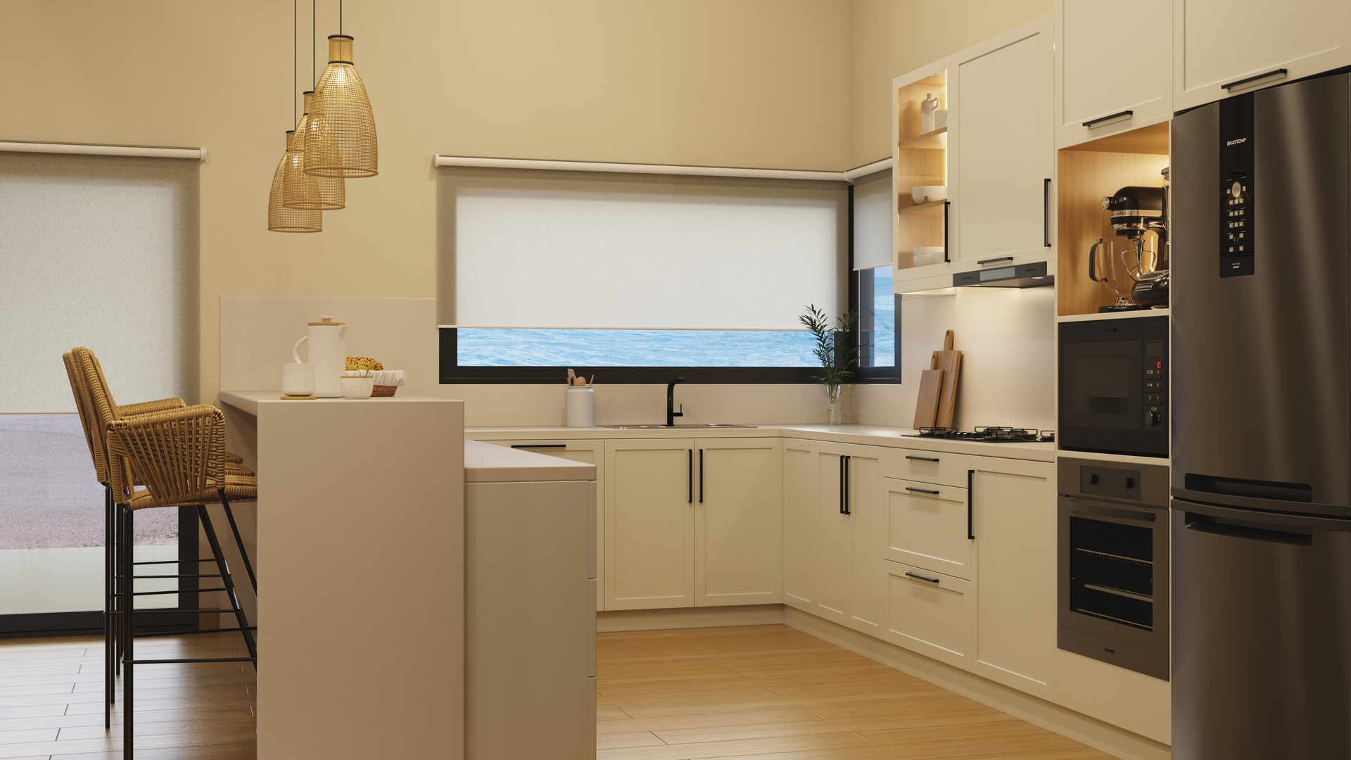 Cocina blanca moderna con barra de desayuno, electrodomésticos de acero inoxidable y vista al mar.