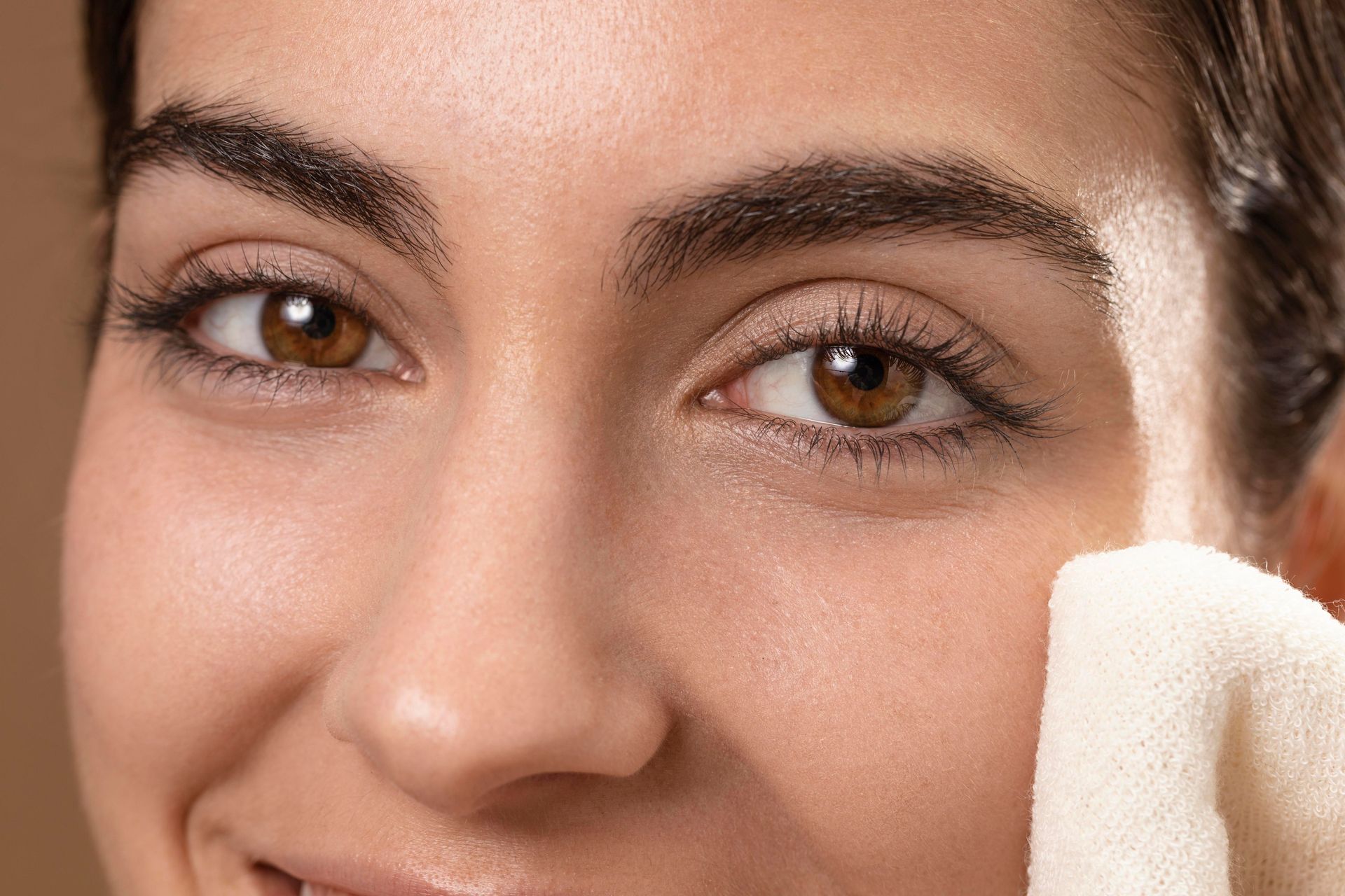 a woman is cleaning her face with a towel