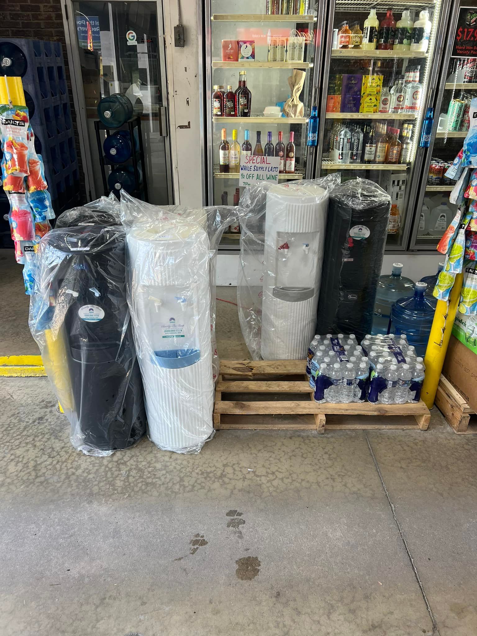 Water filters and bottled water for sale in front of a convenience store.