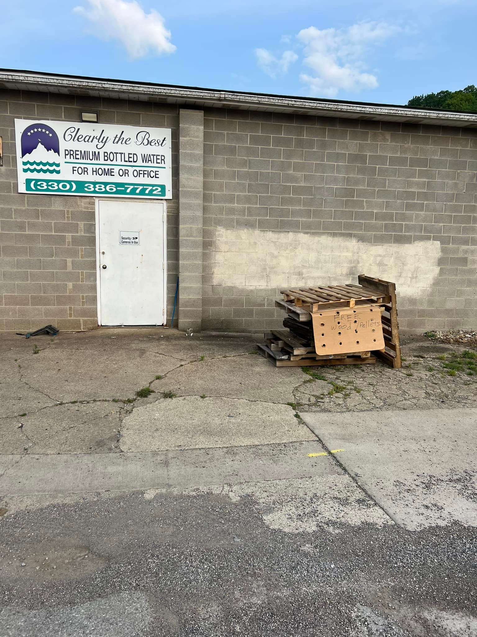 A grey brick building with a white door and a sign that says 