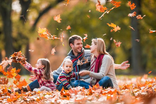 Family sitting in fall leaves
