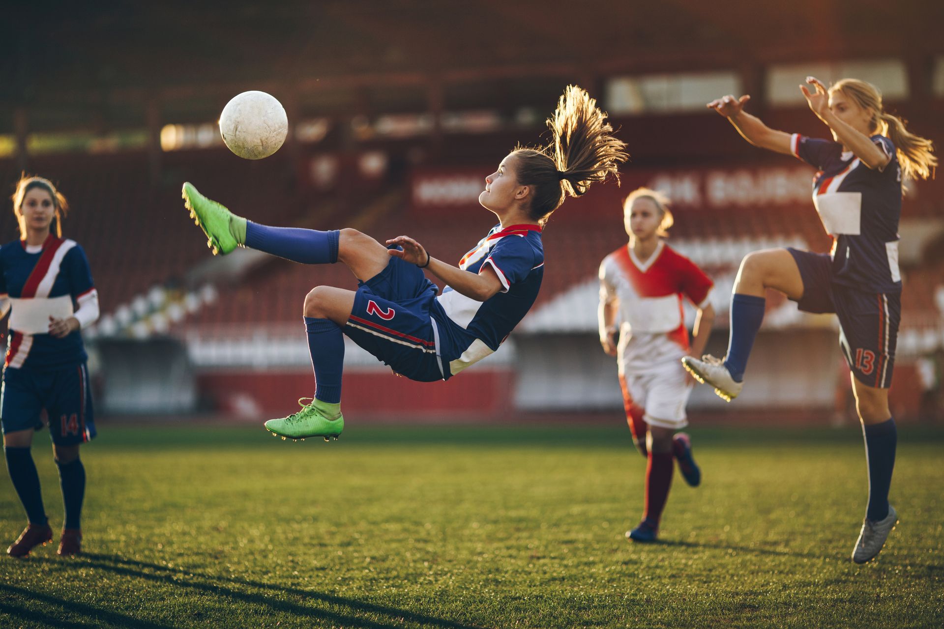 A group of women are playing soccer on a field.