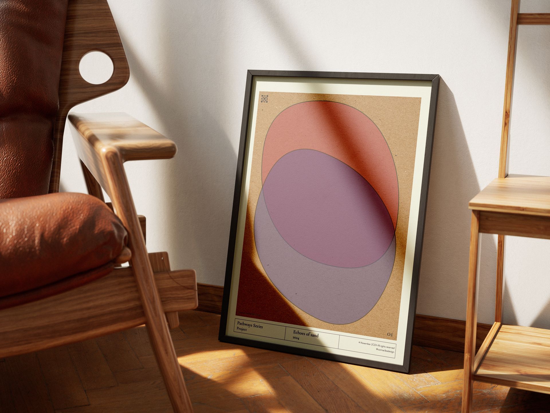 Wooden chair and framed art with overlapping pink, purple, and orange shapes leaning against a wall.